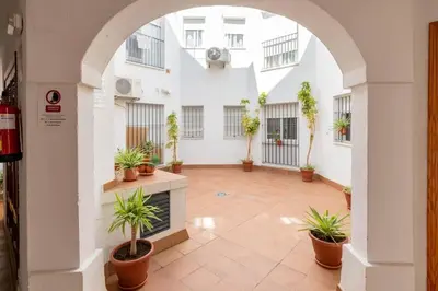 a courtyard with potted plants in a building at Apartamento centro Rota. 2 minutos de la playa.. in Rota