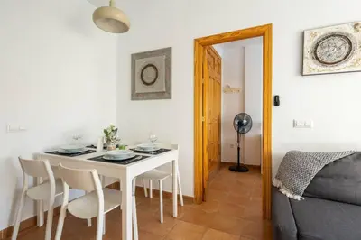 a dining room with a white table and chairs at Apartamento centro Rota. 2 minutos de la playa.. in Rota