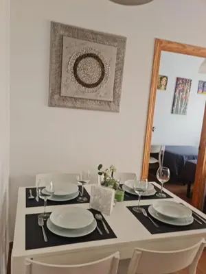 a dining room table with plates and wine glasses at Apartamento centro Rota. 2 minutos de la playa.. in Rota