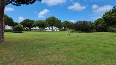 a large grass field with trees in the background at Apartamento Retama Golf in Chiclana de la Frontera