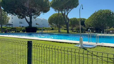 a swimming pool with a fence around it at Apartamento Retama Golf in Chiclana de la Frontera