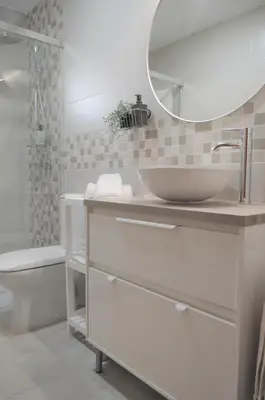 a white bathroom with a sink and a mirror at Bonito apartamento con jardín privado en Novo in Novo Sancti Petri
