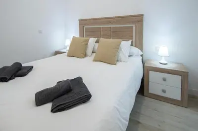 a bedroom with a large white bed with two pillows at Apartamento Las Calas de Cadiz in Cádiz