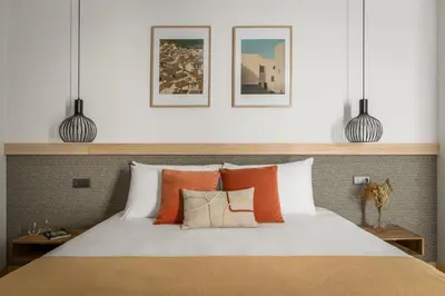 a bedroom with a bed and a nightstand next to a bed with pillows at BYPILLOW La Sal in Cádiz