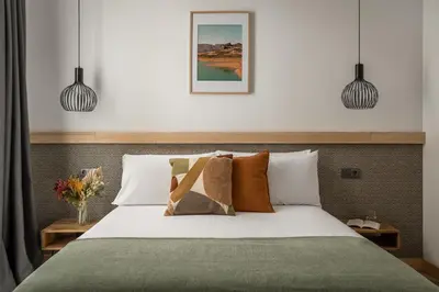two people sitting at a table with a laptop at BYPILLOW La Sal in Cádiz
