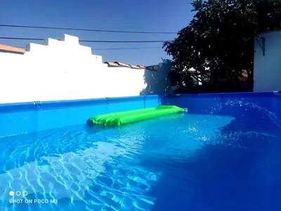 a swimming pool with a green raft in the water at Casa del abuelo trujillo 2 in Conil de la Frontera