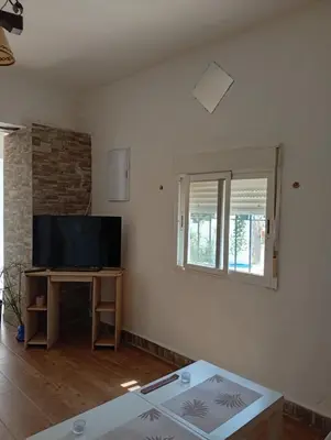 a living room with a tv and a table at Casa del abuelo trujillo 2 in Conil de la Frontera