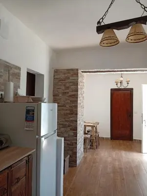 a kitchen with a white refrigerator and a brick wall at Casa del abuelo trujillo 2 in Conil de la Frontera