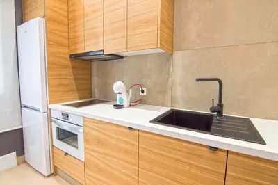 a small kitchen with a sink and a refrigerator at El Patio del Sol, Apartamentos Living Sur in Sanlúcar de Barrameda