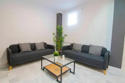 a living room with two couches and a coffee table at El Patio del Sol, Apartamentos Living Sur in Sanlúcar de Barrameda