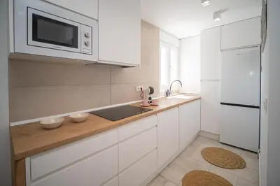 a white kitchen with a sink and a microwave at SibsSanlucar Casa Manuela - Céntrico - Vistas Coto Doñana in Sanlúcar de Barrameda
