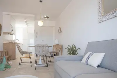 a living room with a blue couch and a kitchen at SibsSanlucar Casa Manuela - Céntrico - Vistas Coto Doñana in Sanlúcar de Barrameda