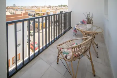 a balcony with a table and a chair on a balcony at SibsSanlucar Casa Manuela - Céntrico - Vistas Coto Doñana in Sanlúcar de Barrameda