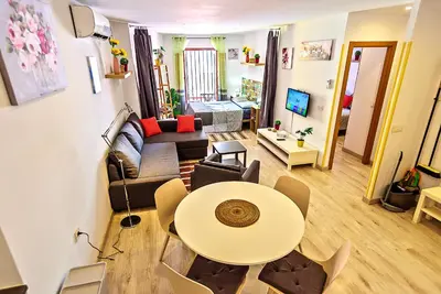 a living room with a table and a couch at Plaza Herrería Central Apartments with Balconies in El Puerto de Santa María
