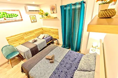 a bedroom with two beds and a blue curtain at Plaza Herrería Central Apartments with Balconies in El Puerto de Santa María