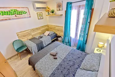 a small room with two beds and a chair at Plaza Herrería Central Apartments with Balconies in El Puerto de Santa María