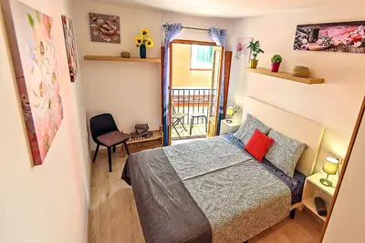 a small bedroom with a bed and a window at Plaza Herrería Central Apartments with Balconies in El Puerto de Santa María