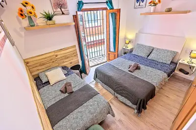 a bedroom with two beds and a mirror at Plaza Herrería Central Apartments with Balconies in El Puerto de Santa María