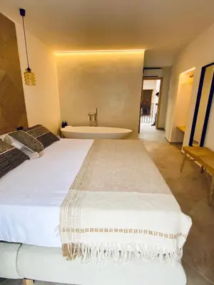 a bedroom with a large bed and a bath tub at VICTORIA - by Ático73 in Medina Sidonia