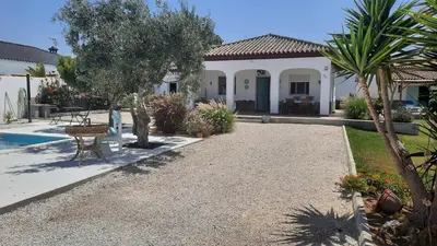 a house with a gravel driveway and a yard at Villa Jaca azule in Chiclana de la Frontera