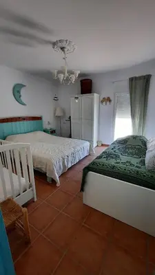 a bedroom with two beds and a chandelier at Villa Jaca azule in Chiclana de la Frontera