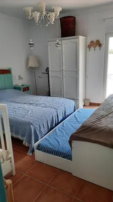 a bedroom with two beds and a white cabinet at Villa Jaca azule in Chiclana de la Frontera