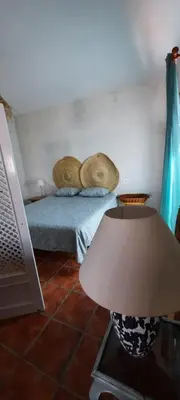 a bedroom with a bed with pillows and a lamp at Villa Jaca azule in Chiclana de la Frontera