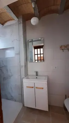 a white bathroom with a sink and a mirror at Villa Jaca azule in Chiclana de la Frontera