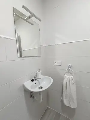 a white bathroom with a sink and a mirror at Alojamientos La Menúa in Los Badalejos