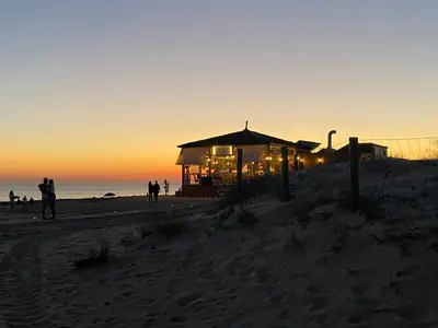a lifeguard station on the beach at sunset at Apartamento en Rota con piscina y parking junto al mar in Rota