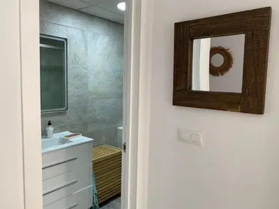 a bathroom with a sink and a mirror at Apartamento en Rota con piscina y parking junto al mar in Rota