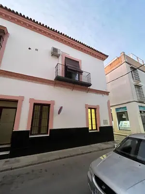 a white building with a balcony on a street at Loft EL DUQUE in Sanlúcar de Barrameda