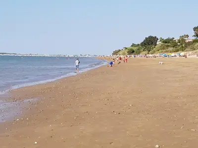 a group of people walking on the beach at Loft EL DUQUE in Sanlúcar de Barrameda