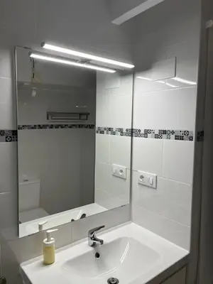 a white bathroom with a sink and a mirror at Loft EL DUQUE in Sanlúcar de Barrameda