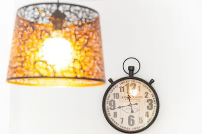 a clock next to a lamp and a chandelier at Casa Melqart in Chiclana de la Frontera