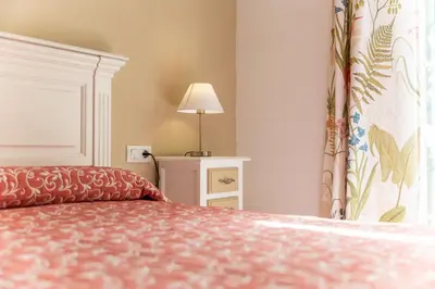 a bedroom with a bed and a lamp and a window at Casa Melqart in Chiclana de la Frontera