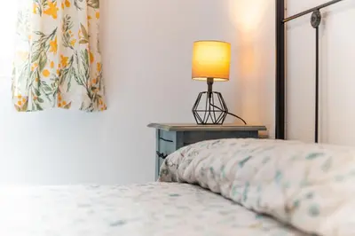 a bedroom with a bed with a lamp on a table at Casa Melqart in Chiclana de la Frontera