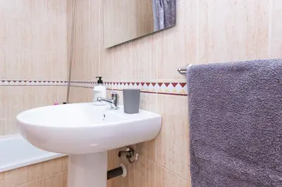 a bathroom with a sink and a mirror and a towel at Casa Melqart in Chiclana de la Frontera
