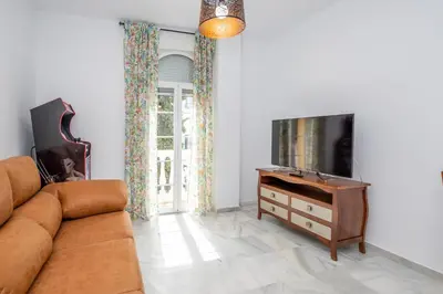 a living room with a couch and a tv at Casa Melqart in Chiclana de la Frontera
