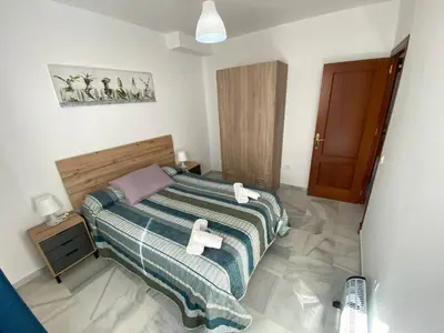 a bedroom with a bed with two towels on it at LAS INFANTAS HOME in Sanlúcar de Barrameda