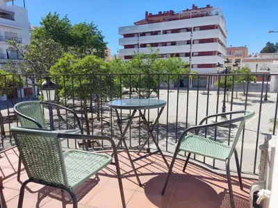 a patio with two chairs and a table and a fence at LAS INFANTAS HOME in Sanlúcar de Barrameda