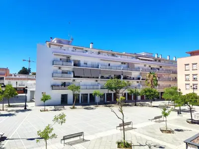 a large white building with benches in a courtyard at LAS INFANTAS HOME in Sanlúcar de Barrameda
