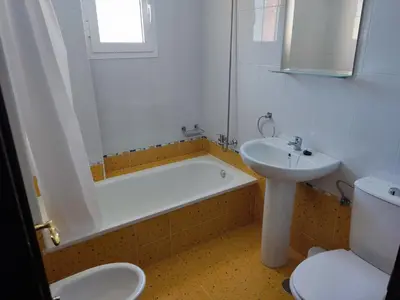 a bathroom with a sink and a tub and a toilet at LAS INFANTAS HOME in Sanlúcar de Barrameda