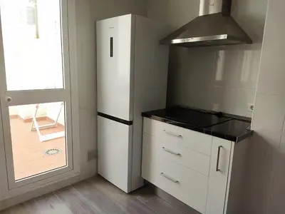 a kitchen with a white refrigerator and a window at LAS INFANTAS HOME in Sanlúcar de Barrameda