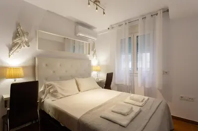 a bedroom with a bed with two towels on it at El Velero en la playa Victoria Grupo AC Gestion in Cádiz