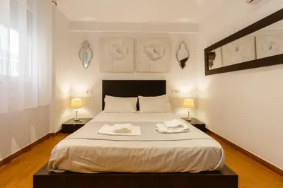 a bedroom with a bed with two towels on it at El Velero en la playa Victoria Grupo AC Gestion in Cádiz