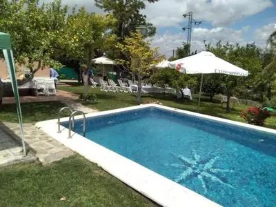 a swimming pool in a yard with an umbrella at Vivienda Rural La choza in Jerez de la Frontera