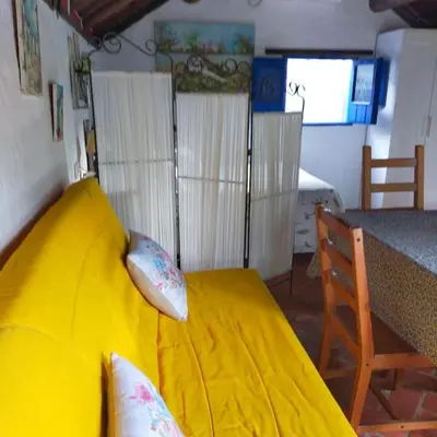 a yellow bed in a room with a table at Vivienda Rural La choza in Jerez de la Frontera