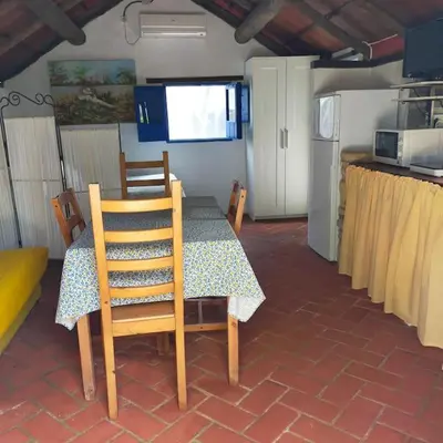 a dining room with a table and chairs and a kitchen at Vivienda Rural La choza in Jerez de la Frontera