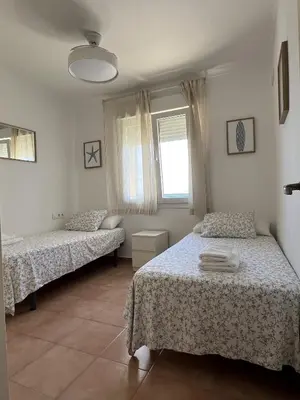 a bedroom with two beds and a window at Apartamento Bajamar in El Puerto de Santa María